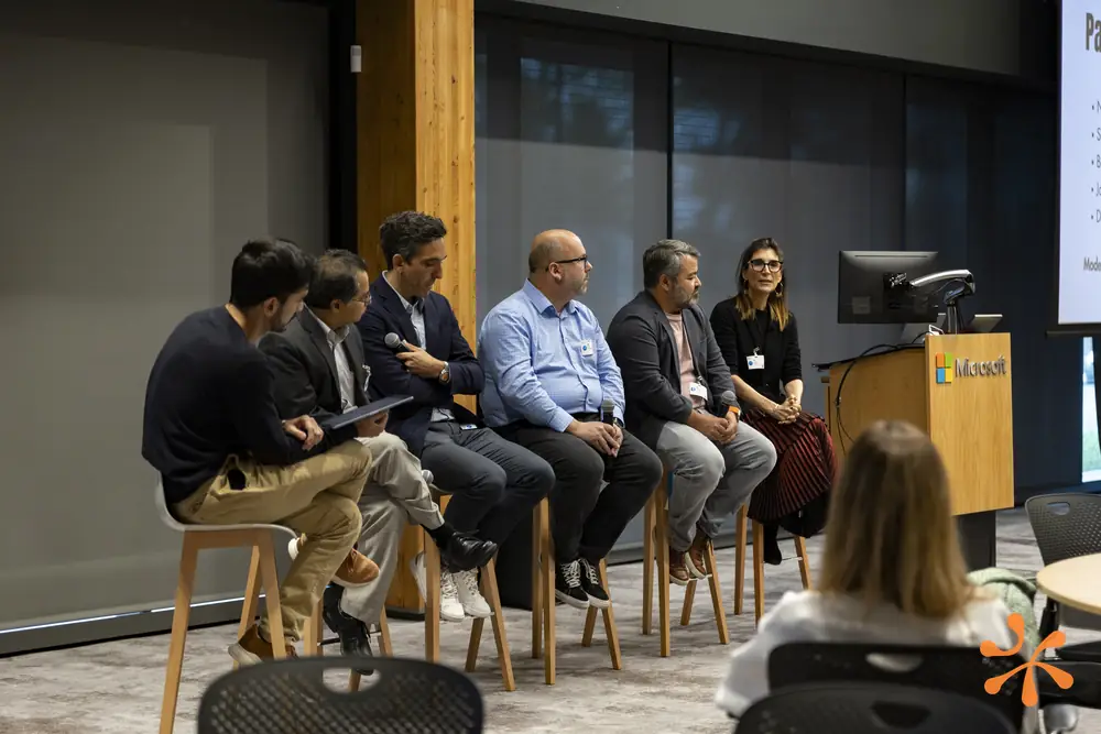 Panelists seated on stools at the Microsoft venue